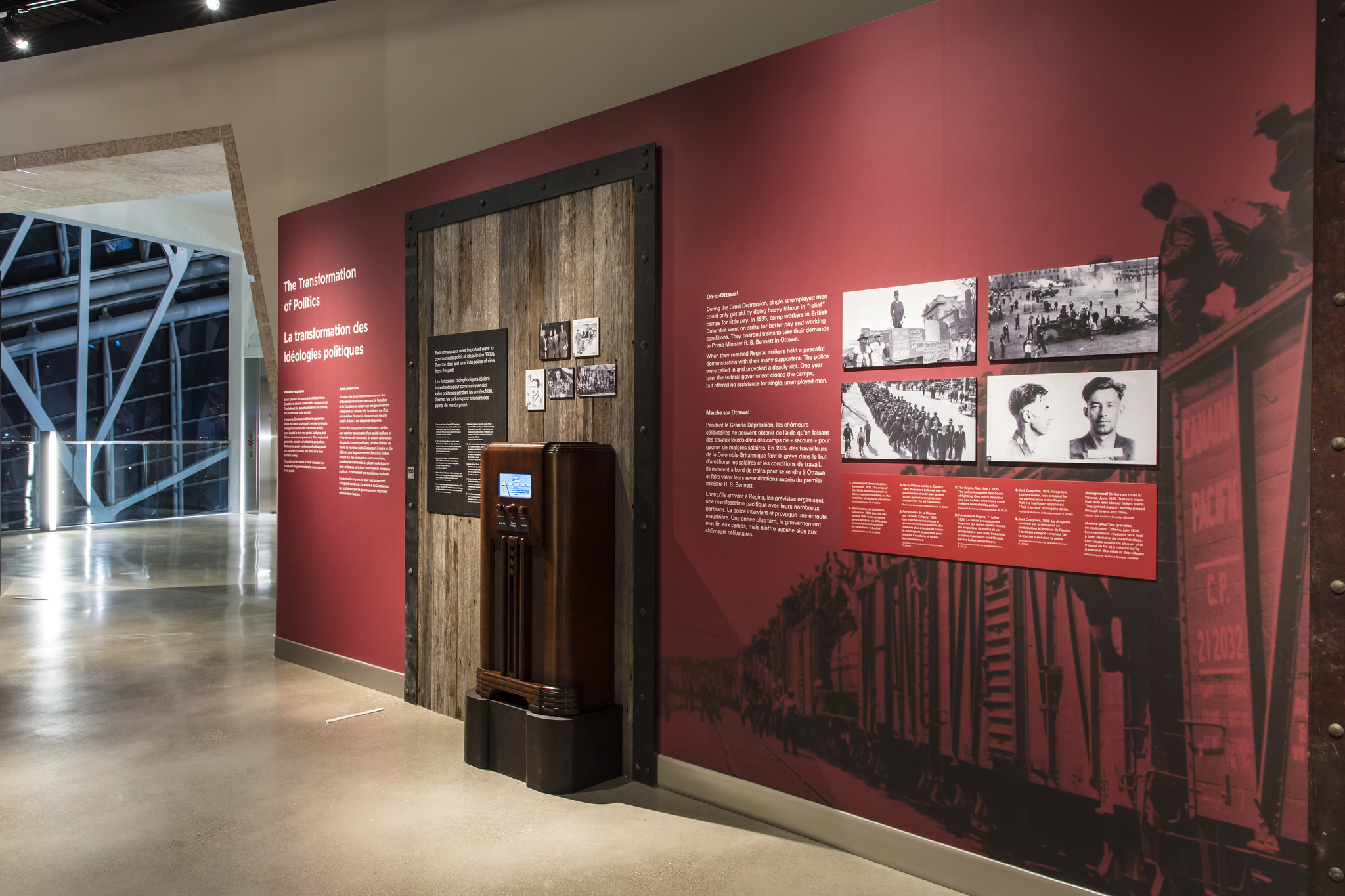 Evening shot of installation wall featuring printed text, images, and a physical vintage radio.