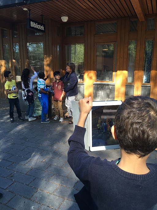 A young student taking a photo with an Ipad.